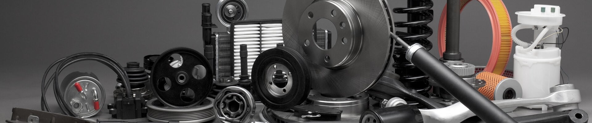 Several auto parts arranged on a plain gray background.